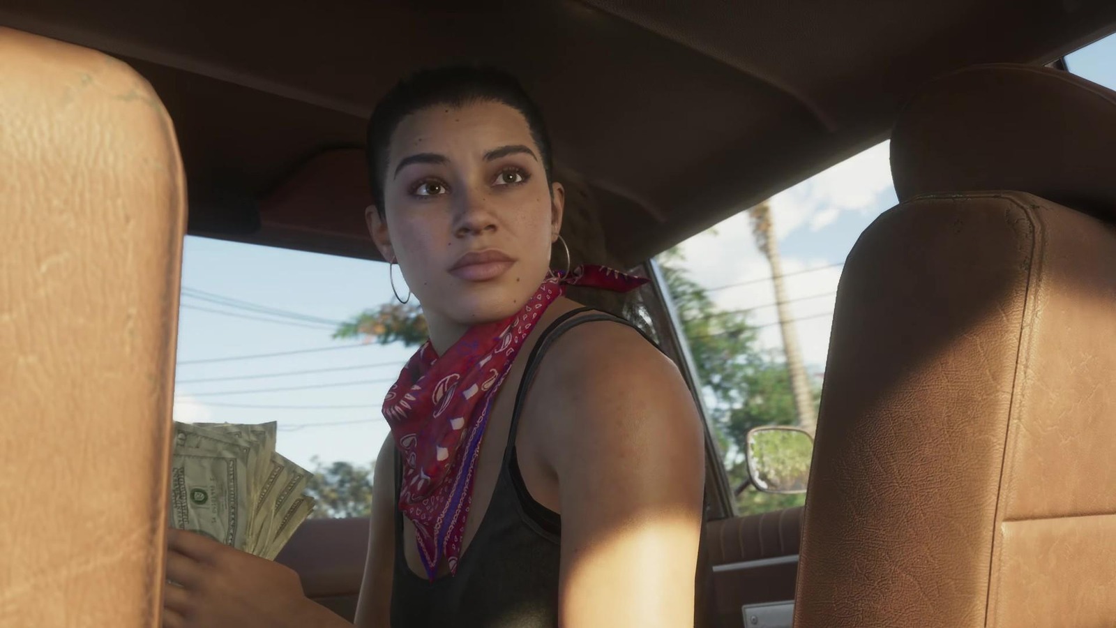 Lucia in auto con del denaro in mano in una scena di GTA VI.